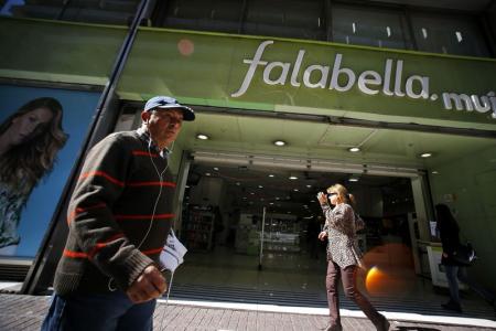 Personas caminan frente a un local de Falabella en Santiago