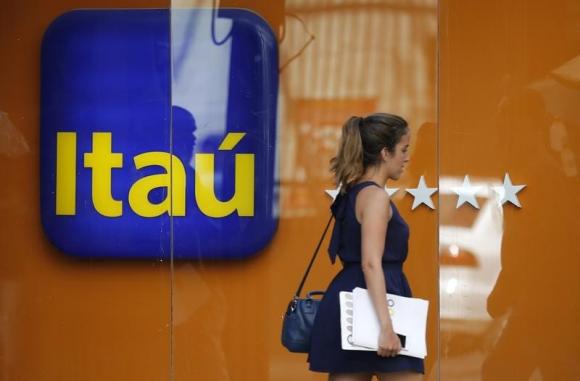 A woman walks past an Itau branch office in Rio de Janeiro
