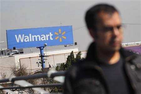 A person walks near a Wal-Mart billboard in Mexico City