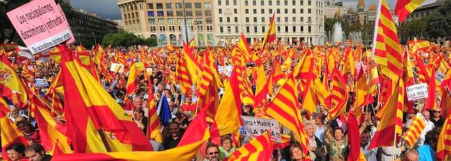 Anti-independentist Catalans hold Catalan and Spanish flags during a